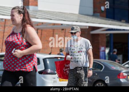 Die Käufer im Gallagher Retail Park stehen während der landesweiten Sperrung des Coronavirus vor langen Warteschlangen vor M&S und B&M. Stockfoto