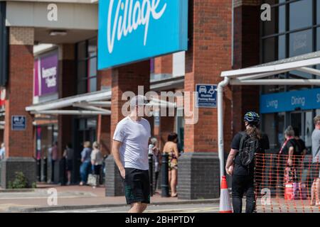 Die Käufer im Gallagher Retail Park stehen während der landesweiten Sperrung des Coronavirus vor langen Warteschlangen vor M&S und B&M. Stockfoto