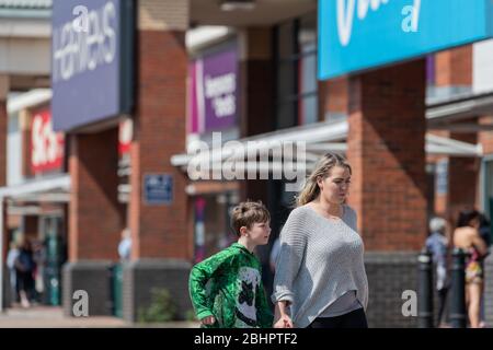 Mutter und Sohn eilen während der landesweiten Sperrung des Coronavirus an der Warteschlange im Gallagher Retail Park. Stockfoto