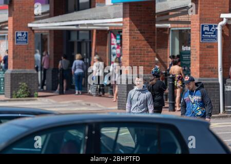 Käufer verlassen den Gallagher Retail Park während der landesweiten Sperrung des Coronavirus. Stockfoto