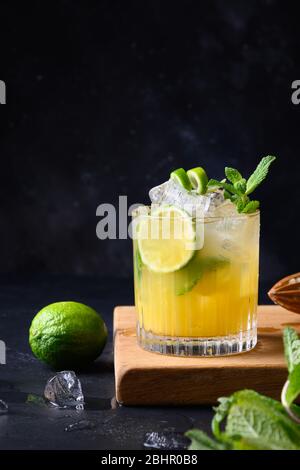 Mai Tai Klassischer Rum-Cocktail. Tropische Limonade mit Limettengarnitur Minze auf Schwarz. Vertikales Format. Stockfoto