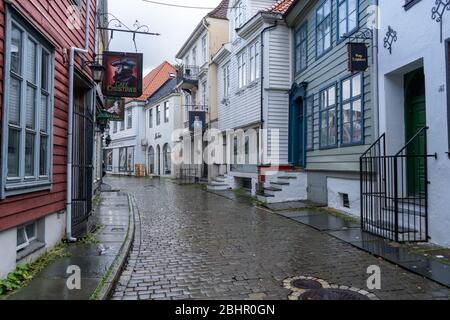 Straße von Bergen Stadt in einem regnerischen Tag. Viele historische Holzhäuser und Straße aus Pflastersteinen. Stockfoto