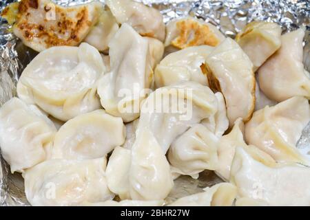 Teller mit traditionellen nepalesischen Essen Momos. Dampf gekochte Momos mit Sauce. Draufsicht. Frisches Essen Buffet Brunch Catering Essen Party Sharing Konzept Stockfoto