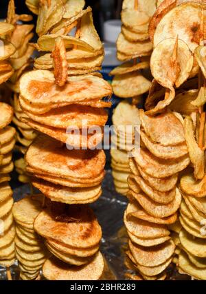 Gebratene Kartoffelspirale auf einem Stock während des Street Food Festivals. Fast Food. Tornado Kartoffeln auf einem Bambusstock Stockfoto