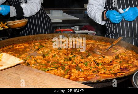 Meeresfrüchte Paella in einer großen Pfanne Wok gekocht, Street Food Festival. Mexikanische Fiesta Nationalgericht Spezialität. Live-Kochstation. Frisches Essen Buffet Frühstück Stockfoto