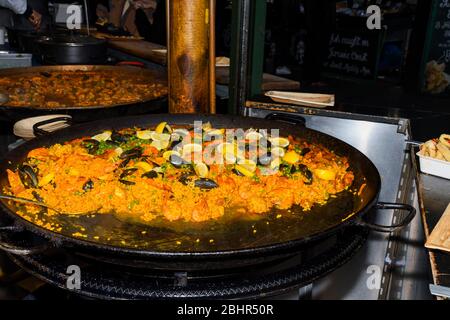 Meeresfrüchte Paella in einer großen Pfanne Wok gekocht, Street Food Festival. Mexikanische Fiesta Nationalgericht Spezialität. Live-Kochstation. Frisches Essen Buffet Frühstück Stockfoto