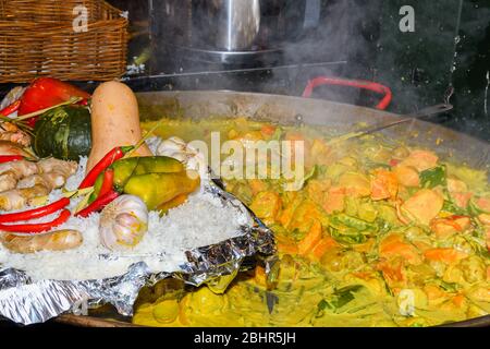 Meeresfrüchte Paella in einer großen Pfanne Wok gekocht, Street Food Festival. Mexikanische Fiesta Nationalgericht Spezialität. Live-Kochstation. Frisches Essen Buffet Frühstück Stockfoto