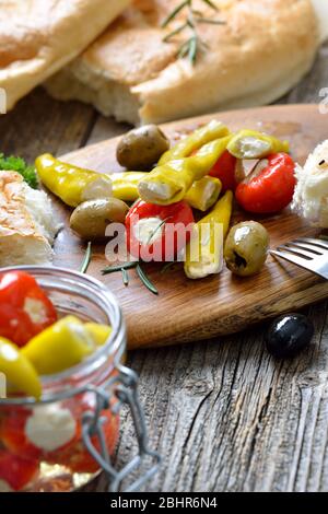 Griechischer Snack: Kirschpaprika und Chili gefüllt mit Frischkäse, serviert mit Oliven und frischem Pita-Brot Stockfoto