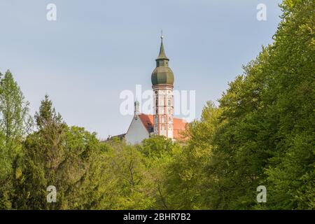 Blick auf die Kirche der Abtei Andechs hinter Bäumen. Kloster Andechs ist in oberbayern bekannt und ein beliebtes Ziel für Pilger. Stockfoto