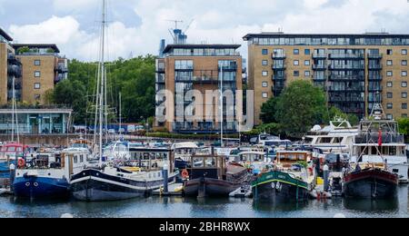 Boote in der Limehouse Marina mit Wohnhochaufliegern im Hintergrund festgemacht. Tower Hamlets, East London, England, Großbritannien Stockfoto