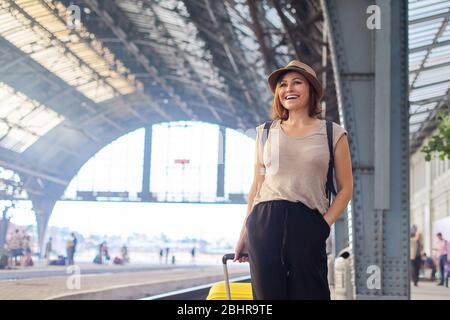 Reife Frau in Hut mit Koffer Rucksack zu Fuß auf Plattform des Bahnhofs. Tourismus, Reisen, Reise, Transport, Menschen mittleren Alters Konzept, Stockfoto