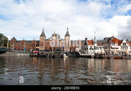 Blick auf den Hauptbahnhof Amsterdam, in der Nähe des Damrak Canal Boat Terminals Stockfoto