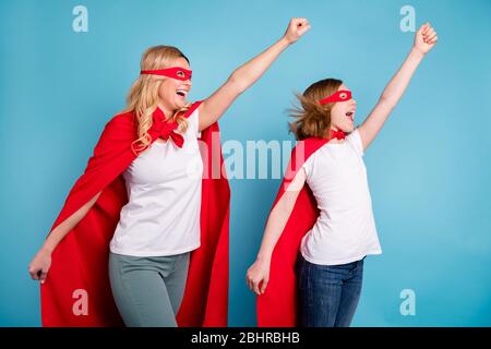 Bereit, los geht's. Foto von lustigen Mutter Dame kleine Tochter Zeit zusammen verbringen Karneval super Helden Kostüme gehen zu fliegen heben Fäuste tragen s-Shirts rot Stockfoto