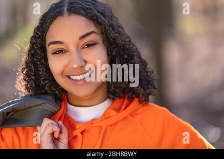 Outdoor-Porträt von schönen glücklich gemischten Rasse biracial afro-amerikanischen Mädchen Teenager weibliche junge Frau lachen und lächeln mit perfekten Zähnen in g Stockfoto