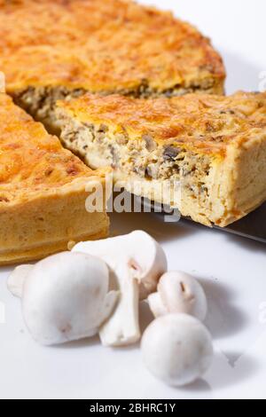 Köstliche Pilzkuchen in Scheiben mit Pilzen im Vordergrund. Stockfoto