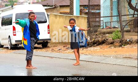 Johannesburg, Südafrika - 17. Januar 2011: Afrikanische Schulkinder spielen auf einer Hauptstraße in Alexandra Township, einer formellen und informellen Siedlung Stockfoto