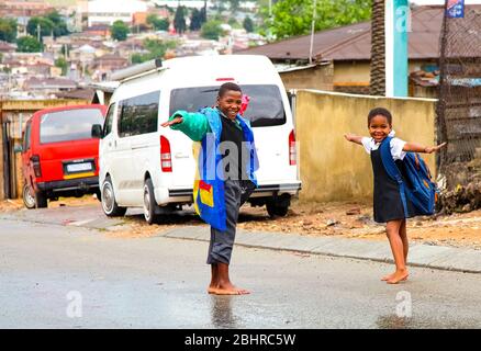 Johannesburg, Südafrika - 17. Januar 2011: Afrikanische Schulkinder spielen auf einer Hauptstraße in Alexandra Township, einer formellen und informellen Siedlung Stockfoto