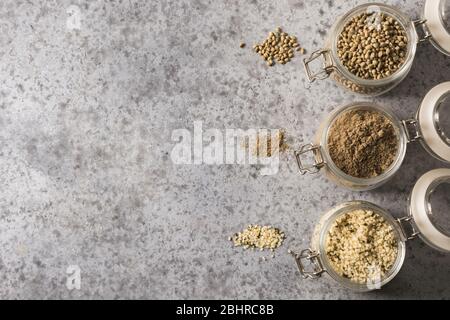 Bio Hanfsamen, Mehl, Kerne in Glas auf grauem Hintergrund. Blick von oben. Platz für Text. Stockfoto