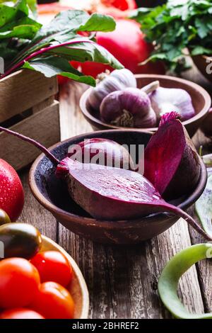 Frisches Bio-Gemüse aus eigenem Anbau auf rustikalem Holztisch, nachhaltiges Leben, gesunde Ernährung, pflanzliche Lebensmittel, Kochzutaten, Rüben, Tomaten Stockfoto