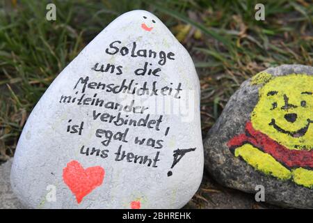 Stralsund, Deutschland. April 2020. Ein bunt bemalter Stein liegt auf einem Wanderweg rund um den Frankenteich. Mit tausenden bunt bemalten Steinen wollen die Menschen in Stralsund in der Corona-Krise Hoffnung geben. Die Steinschlange um den Stralsund Frankenteich ist seit Anfang April auf mehrere hundert Meter gewachsen. Bunt bemalte Steine werden derzeit auch an anderen Stellen in Mecklenburg-Vorpommern verlegt. Quelle: Stefan Sauer/dpa-Zentralbild/dpa/Alamy Live News Stockfoto