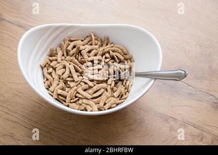 Weiße Schale mit gesunden Cerealien auf Holzhintergrund Stockfoto