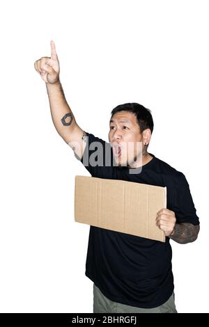 Bärtige asiatische Männer Arbeiter in schwarzen T-Shirts gekleidet hält Pappe und zeigt Point Finger in weißem Hintergrund.das Konzept von Protest, Aufmerksamkeit, re Stockfoto