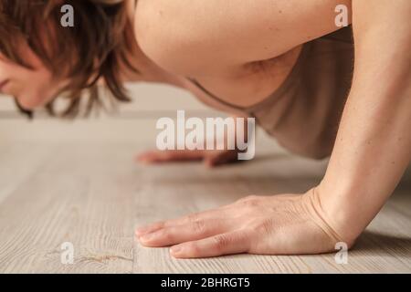 Frau, die Liegestütze Übungen an Händen oder Yoga zu Hause. Nahaufnahme der Hände. Positiver Trend des Körpers. Stockfoto