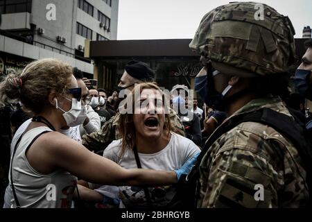 Zouk Mikael, Libanon. April 2020. Ein regierungsfeindlicher Demonstrator schreit während eines Protestes gegen Zouk Mikael gegen die hohen Lebenshaltungskosten und die Abwertung der lokalen Währung auf einen Soldaten. Dutzende Demonstranten versammelten sich und blockierten am Montag wichtige Straßen, um gegen die sich verschlechternde Wirtschaftskrise des Landes zu protestieren und sich einer Sperrung des Coronavirus zu widersetzen. Quelle: Marwan Naamani/dpa/Alamy Live News Stockfoto