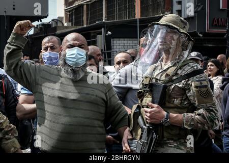 Zouk Mikael, Libanon. April 2020. Ein regierungsfeindlicher Demonstrator schreit neben einem Soldaten während eines Protestes in Zouk Mikael gegen die hohen Lebenshaltungskosten und die Abwertung der lokalen Währung. Dutzende Demonstranten versammelten sich und blockierten am Montag wichtige Straßen, um gegen die sich verschlechternde Wirtschaftskrise des Landes zu protestieren und sich einer Sperrung des Coronavirus zu widersetzen. Quelle: Marwan Naamani/dpa/Alamy Live News Stockfoto