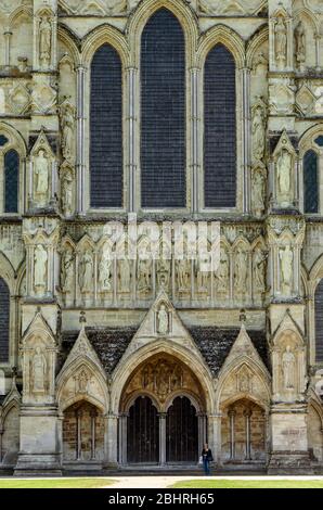 Detail der Great West Front der Salisbury Cathedral mit Passanten, die eine Referenz für Maßstab, Salisbury, Wiltshire, Großbritannien, anbieten Stockfoto