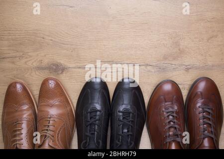 Gruppe von stilvollen Männern Lederschuhe auf Holzhintergrund Stockfoto