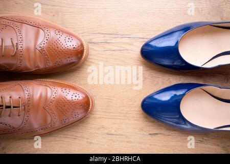 Draufsicht auf stilvolle Lederschuhe eines Mannes und einer Frau auf Holzboden Stockfoto