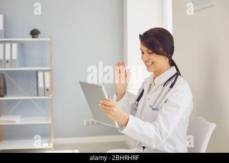 Arzt online. Ärztin mit Tablet-Videoanruf spricht mit Patient durch Geschäftsfrau aus der Ferne. Stockfoto