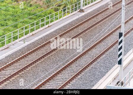 Leere Doppelbahn auf einer Brücke, die sich einem Tunnel von oben nähert. Stockfoto