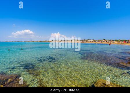 Wunderschönes kristallklares Wasser. Isola delle Correnti (Insel der Strömungen), Portopalo di Capo Passero, Syrakus, Sizilien. Leute, die am Strand baden. Stockfoto