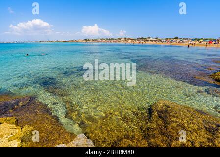 Wunderschönes kristallklares Wasser. Isola delle Correnti (Insel der Strömungen), Portopalo di Capo Passero, Syrakus, Sizilien. Leute, die am Strand baden. Stockfoto