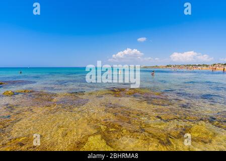 Wunderschönes kristallklares Wasser. Isola delle Correnti (Insel der Strömungen), Portopalo di Capo Passero, Syrakus, Sizilien. Leute, die am Strand baden. Stockfoto