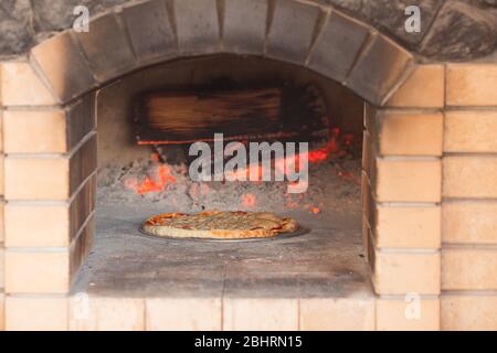 Pizza im Ofen von einem Restaurantkoch zubereiten Stockfoto