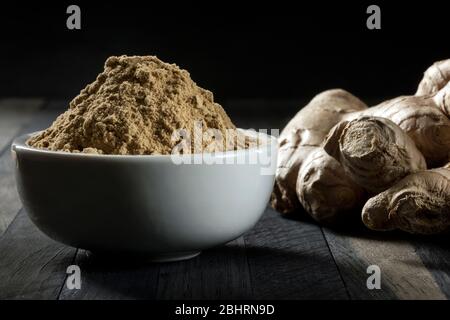 Ingwerwurzel in einer Schüssel auf einem Holztisch gemahlen. Stockfoto