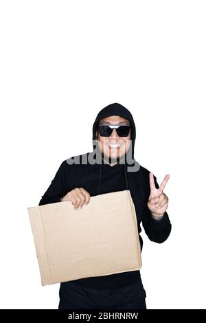Bärtige asiatische Männer in schwarzen Kapuzenpullover ist mit Karton und zeigt Sieg Zeichen in weißem Hintergrund gekleidet.das Konzept des Protests, Aufmerksamkeit, Anfrage. Stockfoto