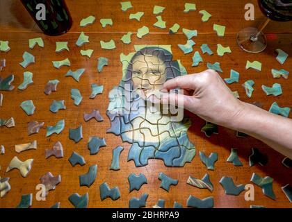 Ein Blick von oben auf ein Mona Lisa Puzzle mit der Hand. Stockfoto
