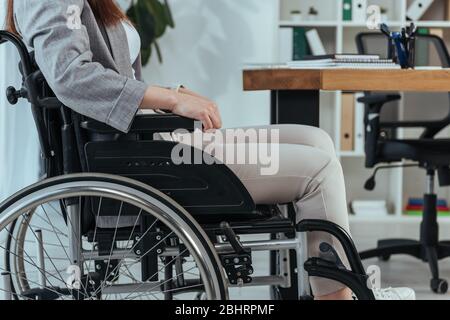 Ansicht von behinderten Mitarbeitern im Rollstuhl am Tisch im Büro Stockfoto