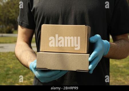 Lieferung Mann in Handschuhen hält leere Boxen, Platz für Text Stockfoto