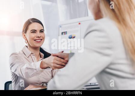 Personalbeschaffer lächelt und schüttelt sich die Hände mit dem Mitarbeiter beim Vorstellungsgespräch im Büro Stockfoto