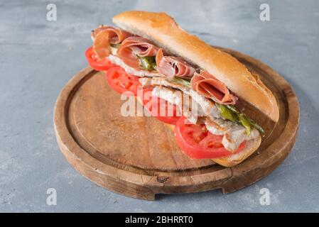 Sandwich Serranito typisch in Andalusien mit Schinken, gren Pfeffer und gegrilltem Schweinefleisch Lende Stockfoto