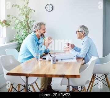 Porträt zweier hochrangiger Geschäftsleute, die im Büro über ein Dokument diskutieren Stockfoto