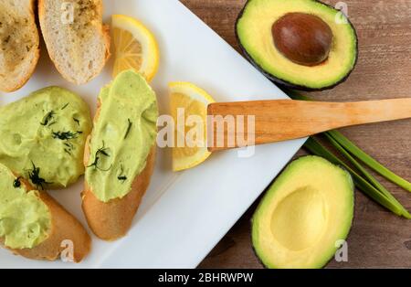 Gesundes Frühstück, Snack. Nahaufnahme von Baguette-Scheiben mit frischer, hausgemachter Avocado-Pasta-Creme. Avocado, Eier, Zitronensaft, Olivenöl, Salz und Pfeffer Stockfoto