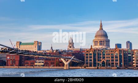 Am späten Nachmittag einen Blick auf die Millennium Foot Bridge, St Pauls Cathedral und dem nördlichen Ufer der Themse, London, England Stockfoto