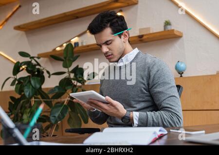 Selektiver Fokus der besorgten Geschäftsmann mit digitalen Tablet am Tisch im Büro Stockfoto