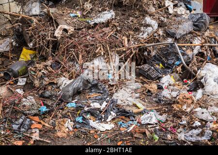 Stapel von weggeworfenen organischen, Kunststoff- und Metallmaterialien in Mülltonne im Freien Stockfoto